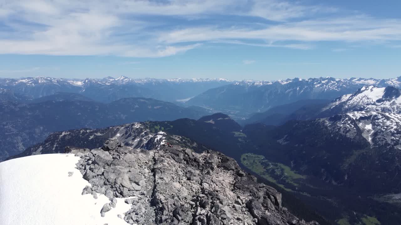 excursionistas descansando en un dron aéreo del paisaje de la cima de la montaña que muestra las cordilleras del pacífico en la columbia británica canadá 4k