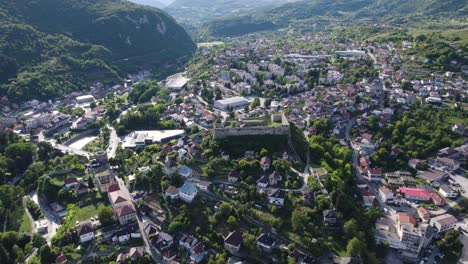 aerial orbiting shot over the walled city of jajce and jajce fortress on steep hill, bosnia and herzegovina