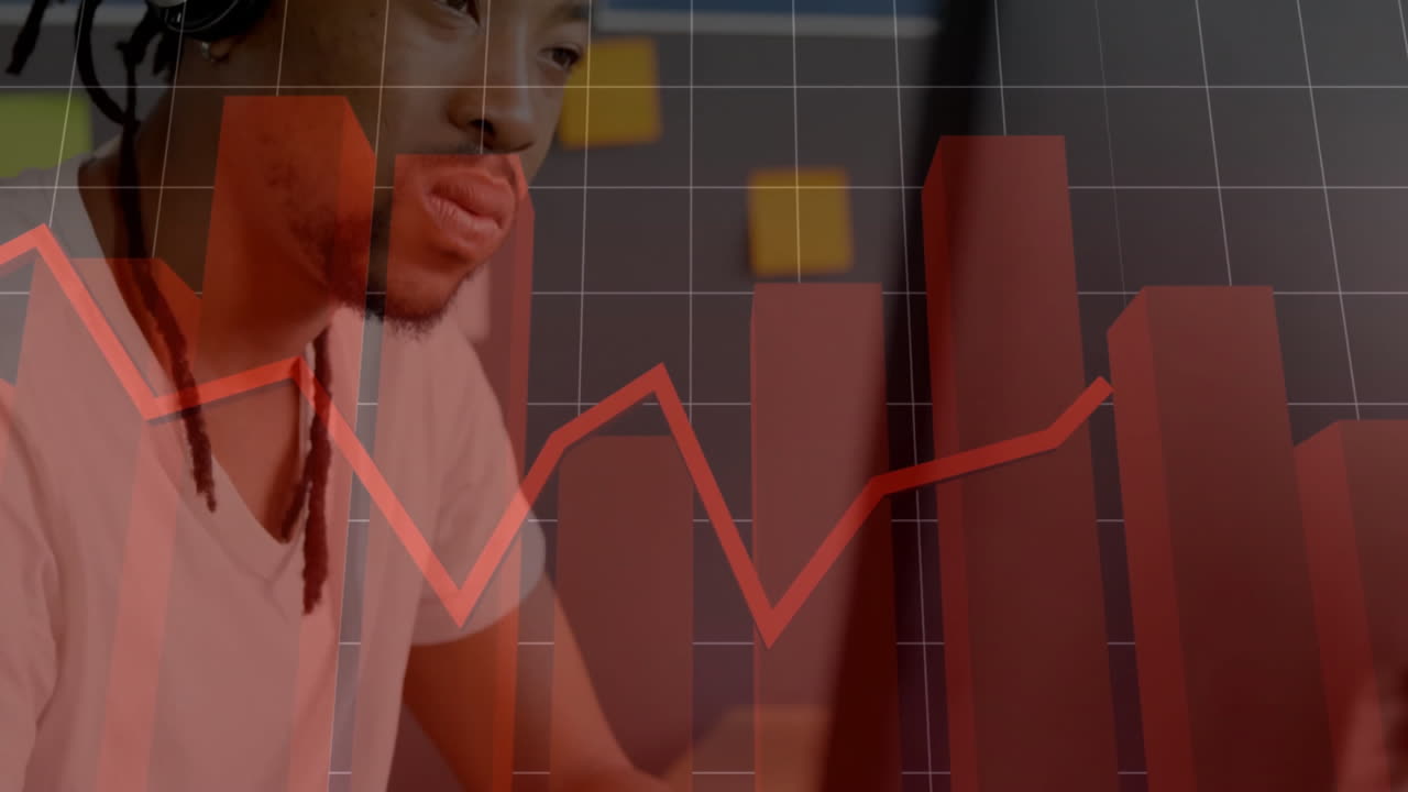 Bar chart and line graph animation over person working on laptop