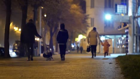 cinematic bokeh with night city street and people in the light of headlights and lanterns