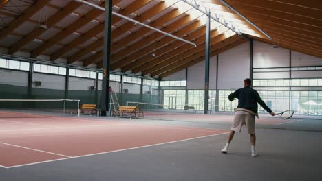 man playing tennis in an indoor court