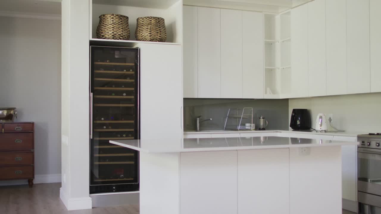 electrodomésticos y muebles construidos en blanco en la cocina de plan abierto y el comedor de una casa moderna