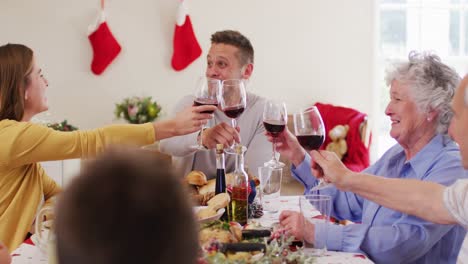 Kaukasische-Familie-Toastet,-Während-Sie-Am-Esstisch-Sitzt