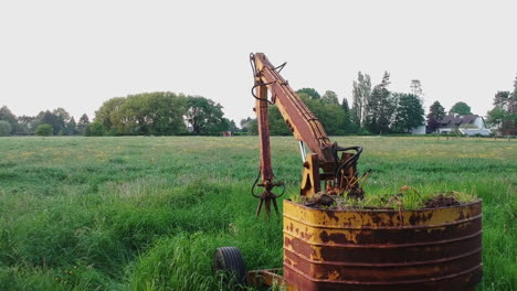 Pull-back-revealing-overgrown-excavator-in-green-field