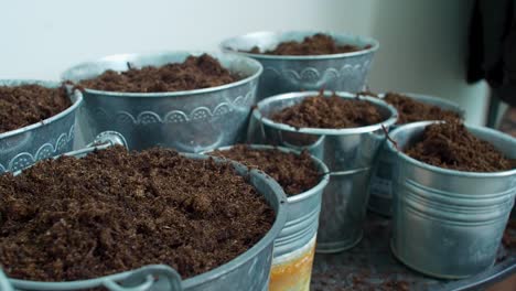 the pots are being filled with soil, as the earth is poured into them