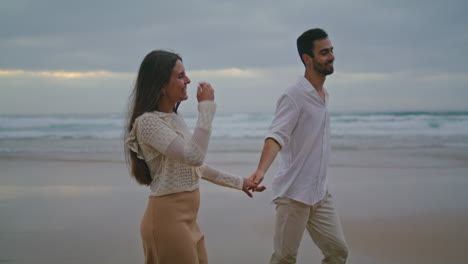 Playful-pair-talking-dark-ocean-closeup.-Lovers-holding-hands-evening-sea-coast