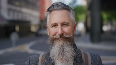 portrait-of-confident-mature-businessman-with-beard-smiling-happy-enjoying-successful-urban-lifestyle-commuter-wearing-stylish-fashion-in-city-street-background-slow-motion