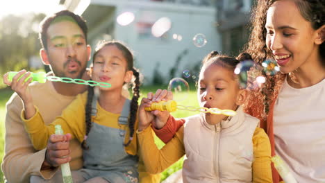 kids, garden and a family blowing bubbles together