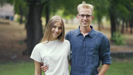 beautiful young couple posing against the backdrop of the park. go for a walk. romantic date. blondes. happiness