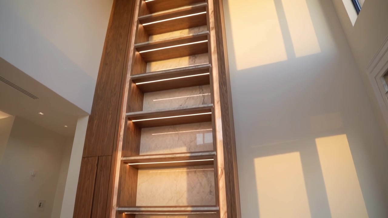 Tilting camera upward revealing tall built-in wooden shelving in living room, showing design