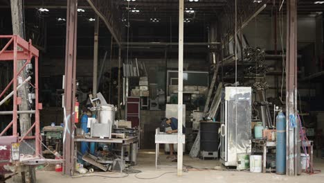 a man working in a cluttered industrial workshop