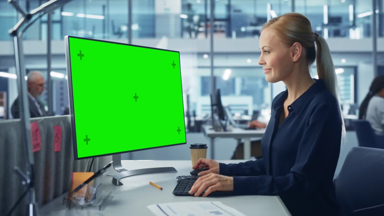 ufficio moderno diversificato: donna d'affari sicura che utilizza un computer desktop con schermo verde. manager che lavora sul supporto del commercio elettronico, il marketing dei progetti, l'analisi dei dati