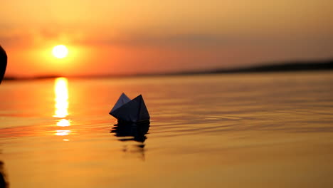 paper ship in children hand. little boy launch paper ship on the water