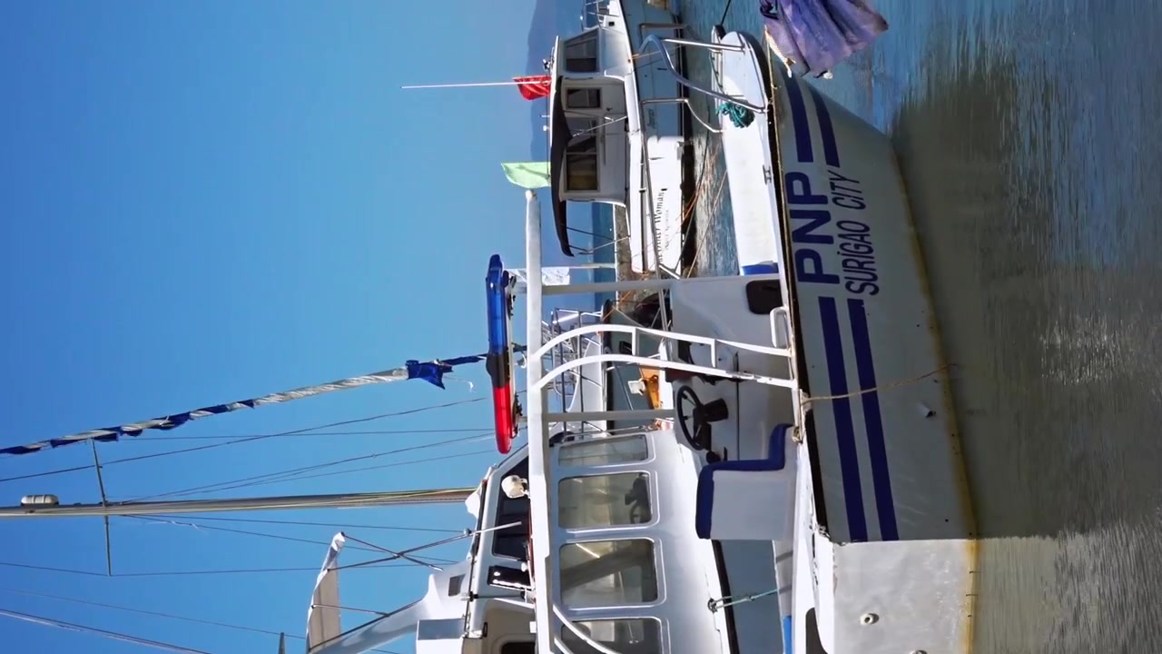 Vidéo verticale - PNP Police nationale philippine, bateau côtier et autres yachts amarrés à Surigao. Philippines