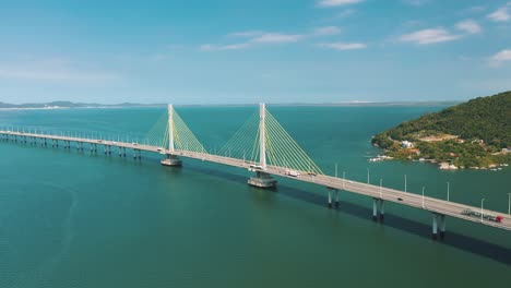 Amazing-panoramic-aerial-shot-Anita-Garibaldi-bridge-above-the-turquoise-color-ocean,-located-in-Laguna,-Santa-Catarina,-Brazil
