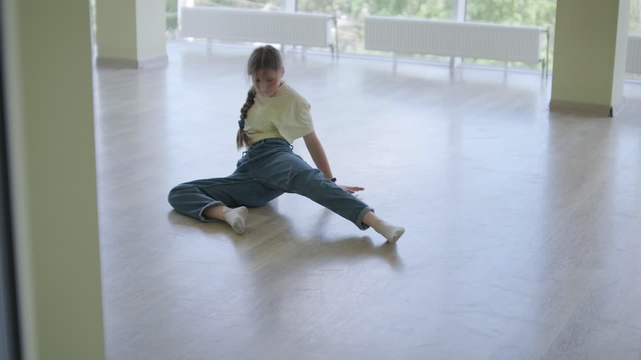 una chica joven bailando breakdance en un estudio moderno.