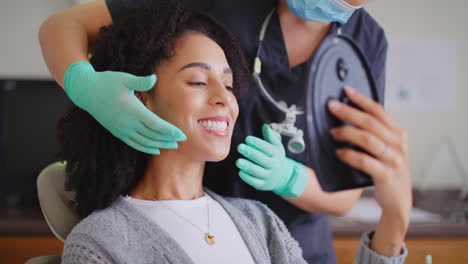 Dentista-Mostrando-Espejo-De-Paciente-Femenino-Para-Comprobar