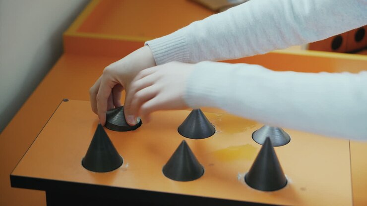 Boy is trying to pick up the metal cones. Museum of entertaining sciences. Concept of physics