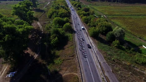 Cyclists-group-riding-on-country-highway-on-bike-ride.-Bicycle-racing-on-highway