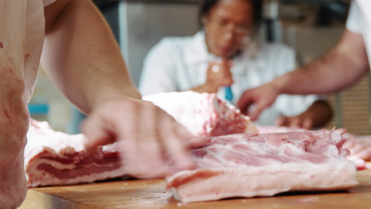 Young butcher preparing meat at butcher's shop, mid section
