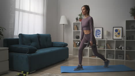 joven sexy está haciendo sentadillas con pesas entrenamiento solo en el gimnasio de casa conejo se mantiene en forma y trabaja los músculos del culo entrenamiento en la sala de estar
