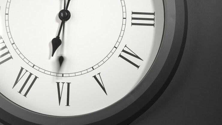 Latin Clock Face in Time Lapse on Dark Grey Wall