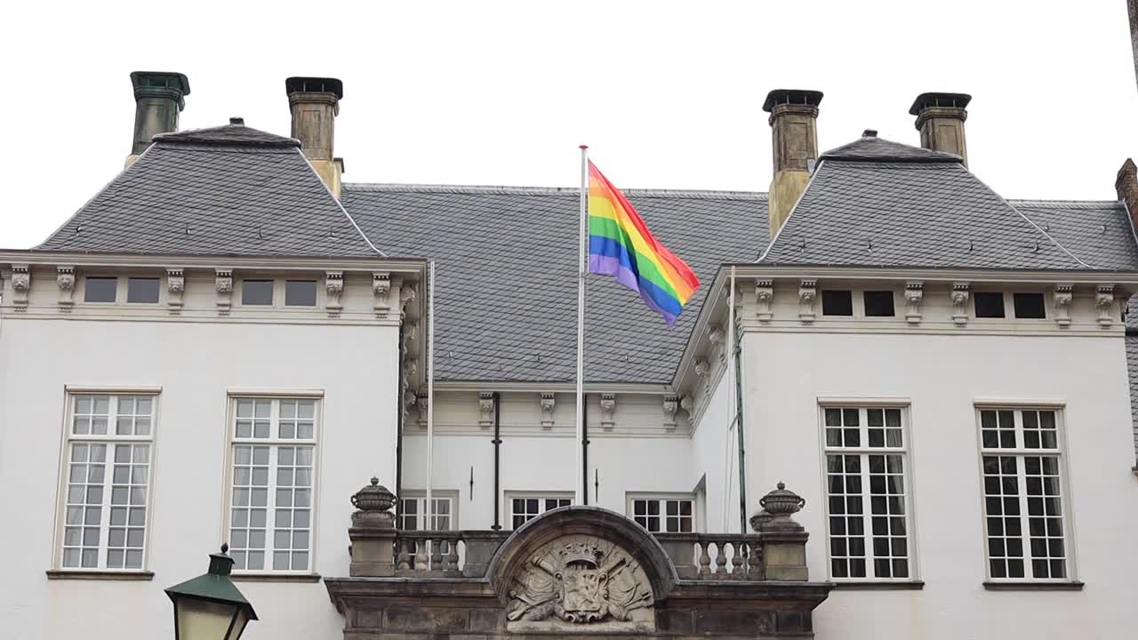 bandera lgbtq+ de color arcoiris en la parte superior de la fachada histórica del ayuntamiento en zutphen, países bajos, ondeando suavemente en apoyo de la comunidad