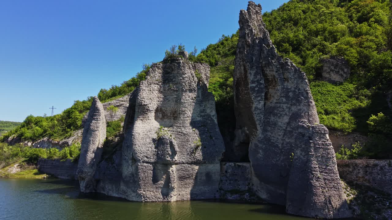 Beautiful rocky cliffs next to a calm river in summer daylight