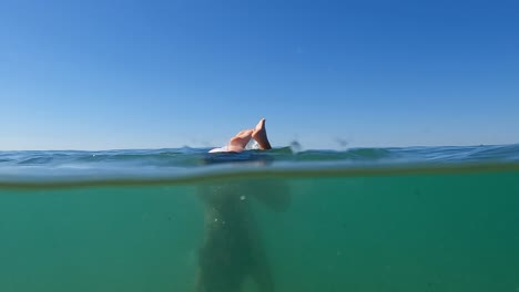 Escena-Semisubmarina-De-Una-Joven-Pelirroja-Haciendo-El-Pino-En-Agua-De-Mar-Con-El-Horizonte-En-El-Fondo