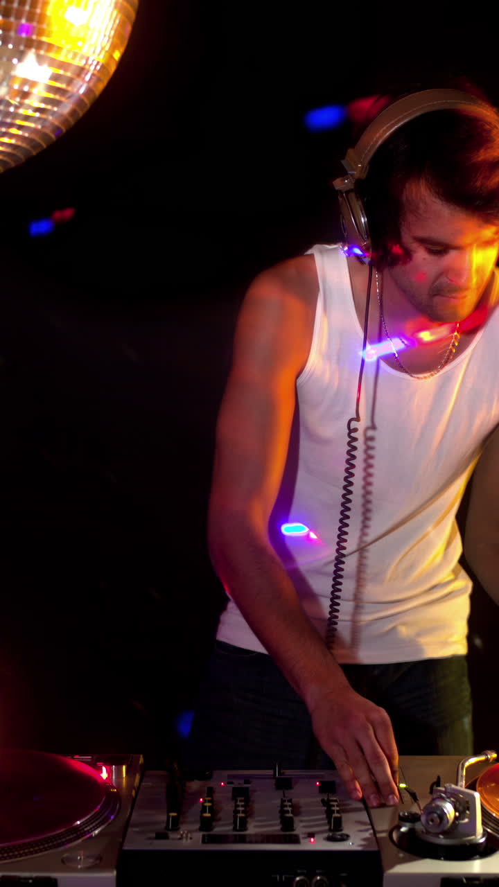 dj masculino detrás de los tocadiscos en vertical