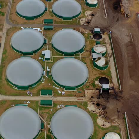 modern biogas plant on field. flying over the storage tanks for biomass production. environmentally friendly biogas plant. top view.
