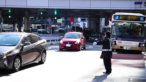 uniformed officer directing vehicles at a crosswalk