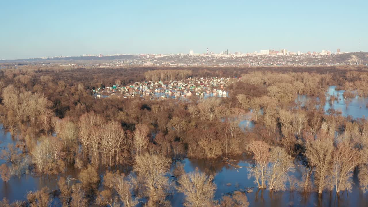 деревня в зоне затопления талой воды, окруженная многими деревьями на фоне ярко-голубого неба. концепция сезонных изменений погоды.