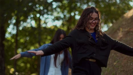 two young women balancing and walking in a park