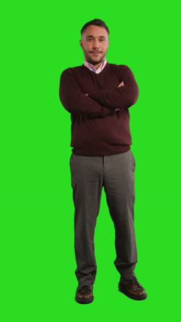 a confident man standing against a green screen.