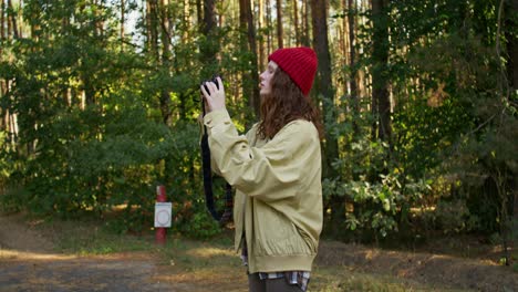 mujer tomando fotos en un bosque