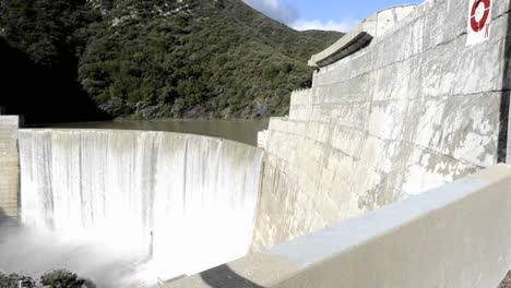 dolly shot of matilija creek spilling over the obsolete matilija dam after a spring storm near ojai california