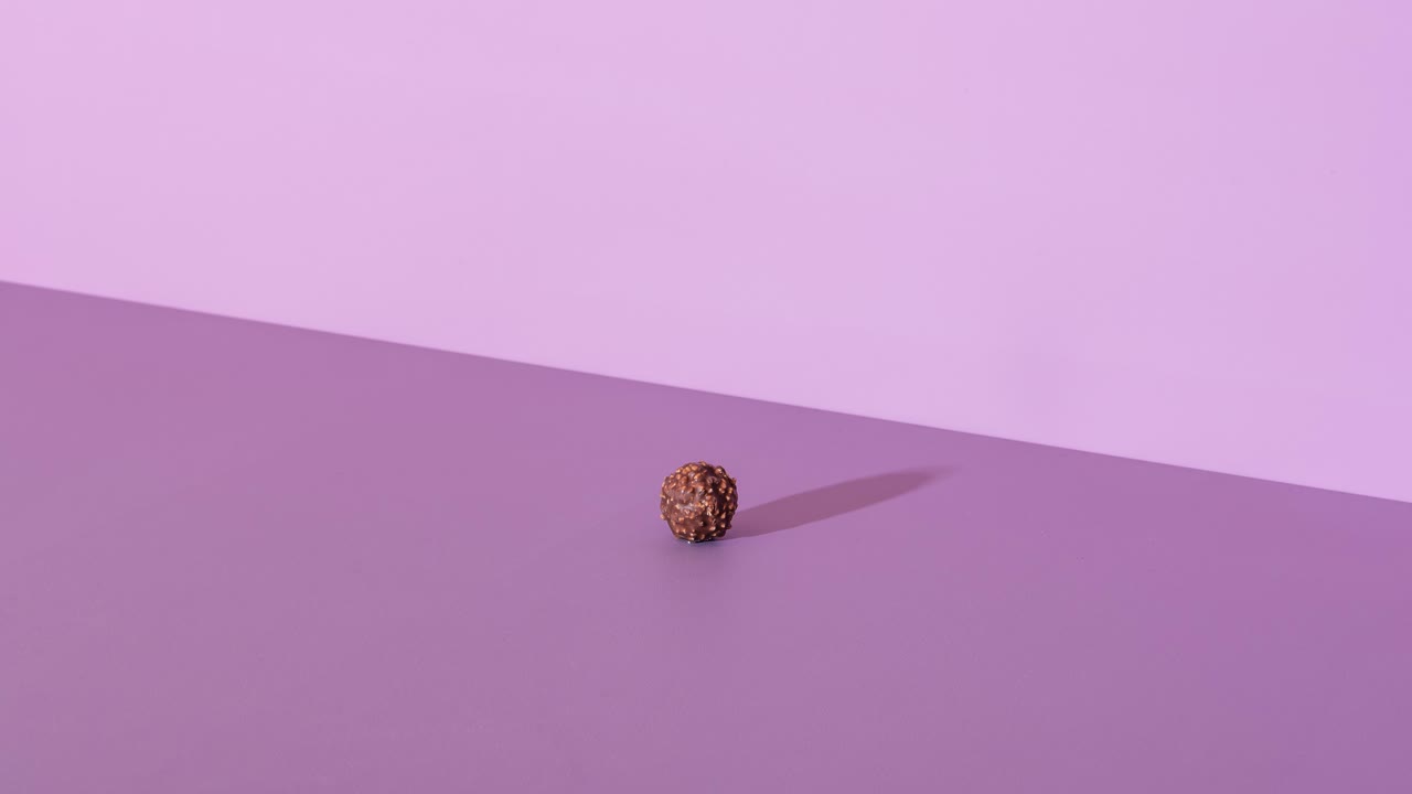 Stop motion video with chocolate candies stacking on a purple table