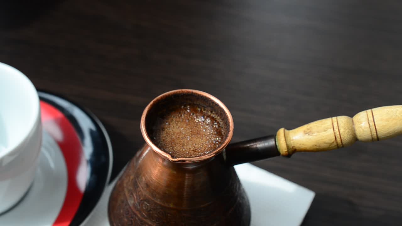 Gezve and cup of coffee. Shooting of coffee on a table