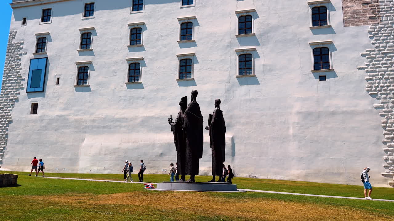 Bratislava, Slovakia, 2 June 2025: Sculpture of Saint Cyril, Methodius and Gorazd near the eastern terrace of the Bratislava Castle in Slovakia. Visitors walk near the landmark