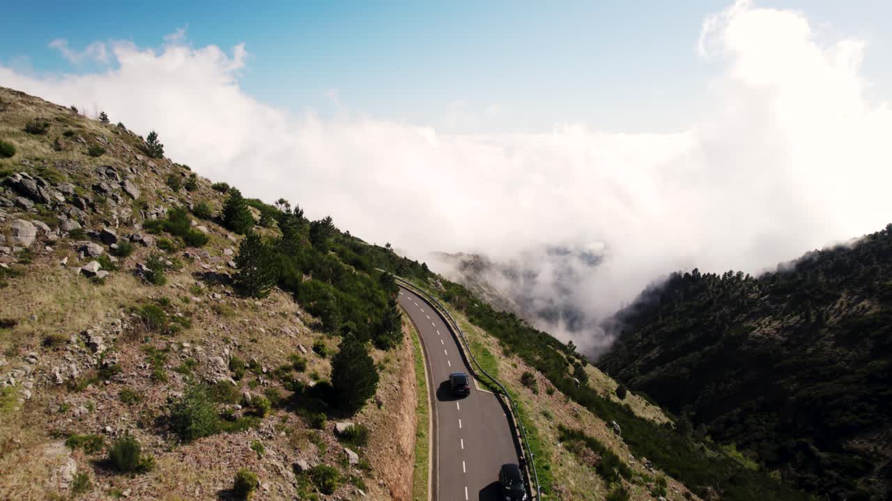 tomada de un avión no tripulado de un coche en movimiento en una carretera panorámica curva, inversión en un día soleado, avión no pilotado de madeira