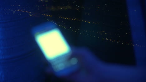 sms typing by the window at night