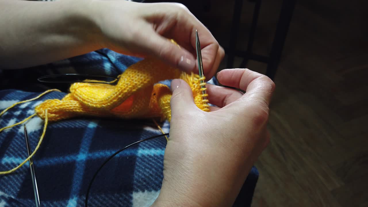 여성의 손은 뜨개질 바늘과 함께 양털 재을 니다.  뷰, 손과 뜨개짐의 클로즈업.