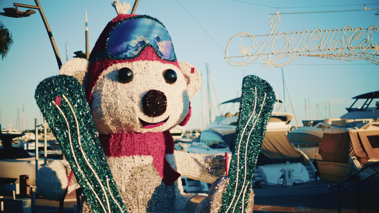 A colorful winter themed polar bear statue with skis stands in a marina decorated for the holidays