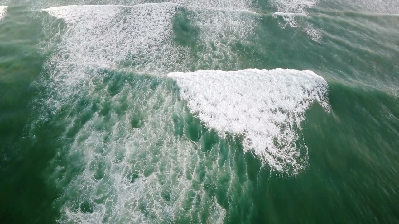 increíble vista aérea de las olas azules del océano espumando y chocando en la costa exótica con palmeras verdes de la isla tropical