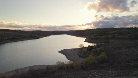 stunning aerial view of clearcut forest and autumnal lake around german harz at sunset