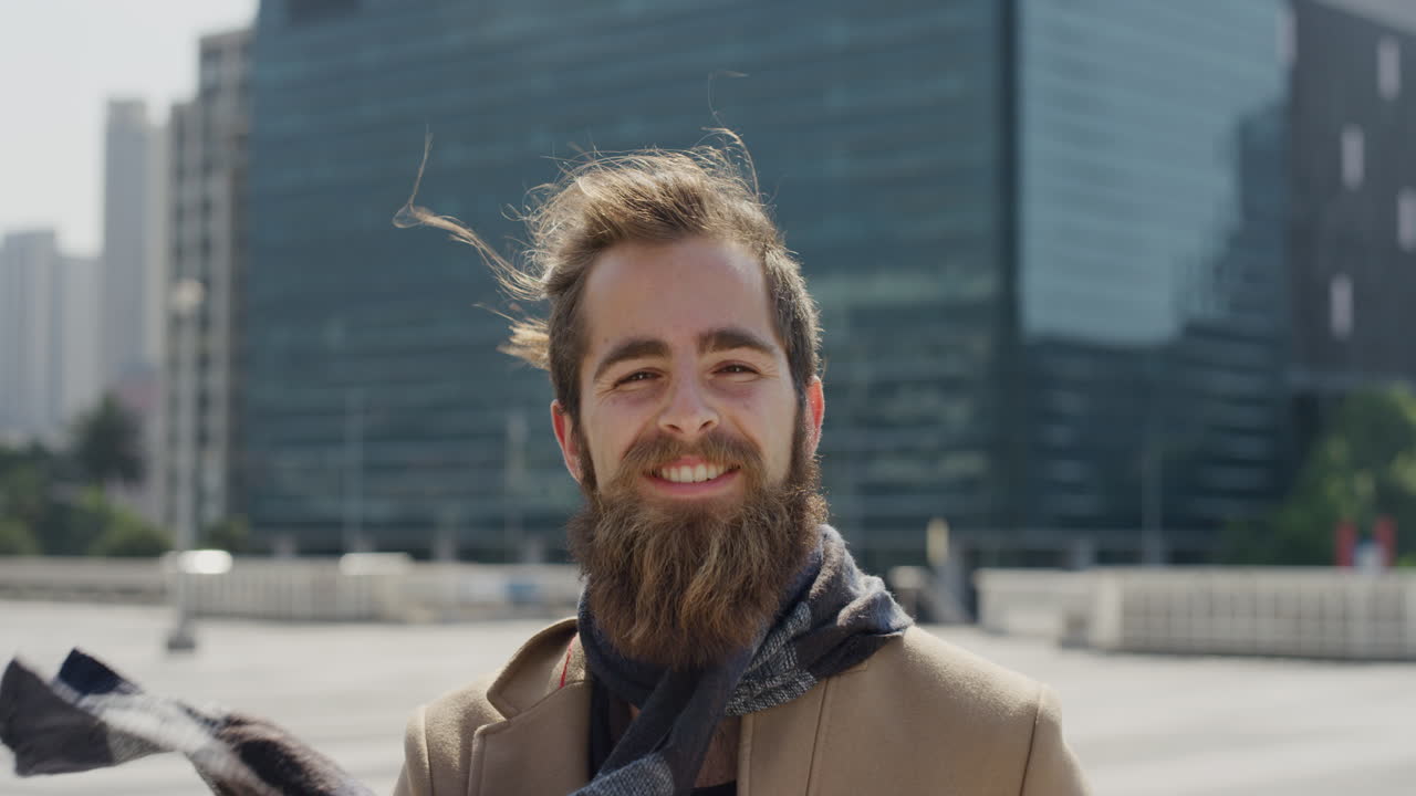 retrato profesional joven hombre hipster sonriente disfrutando de un estilo de vida urbano exitoso feliz empresario barbudo en la ciudad soleada al aire libre cámara lenta
