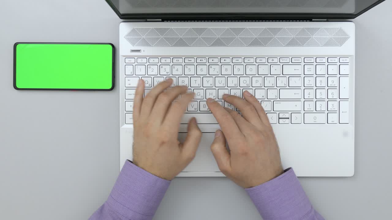 hombre de negocios escribiendo en una computadora portátil en el escritorio. pantalla verde teléfono inteligente. estudiante estudiando. vista superior mesa de trabajo diseñador creativo. freelance trabajando en computadora de escritorio. taza de café. mesa de oficina espacio de trabajo.