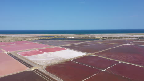 Aerial-view-over-pink-salt-marshes-and-mediterranean-sea-in-background-France