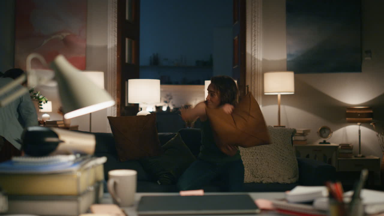Playing couple fighting flat closeup. Funny woman throwing pillow at spouse